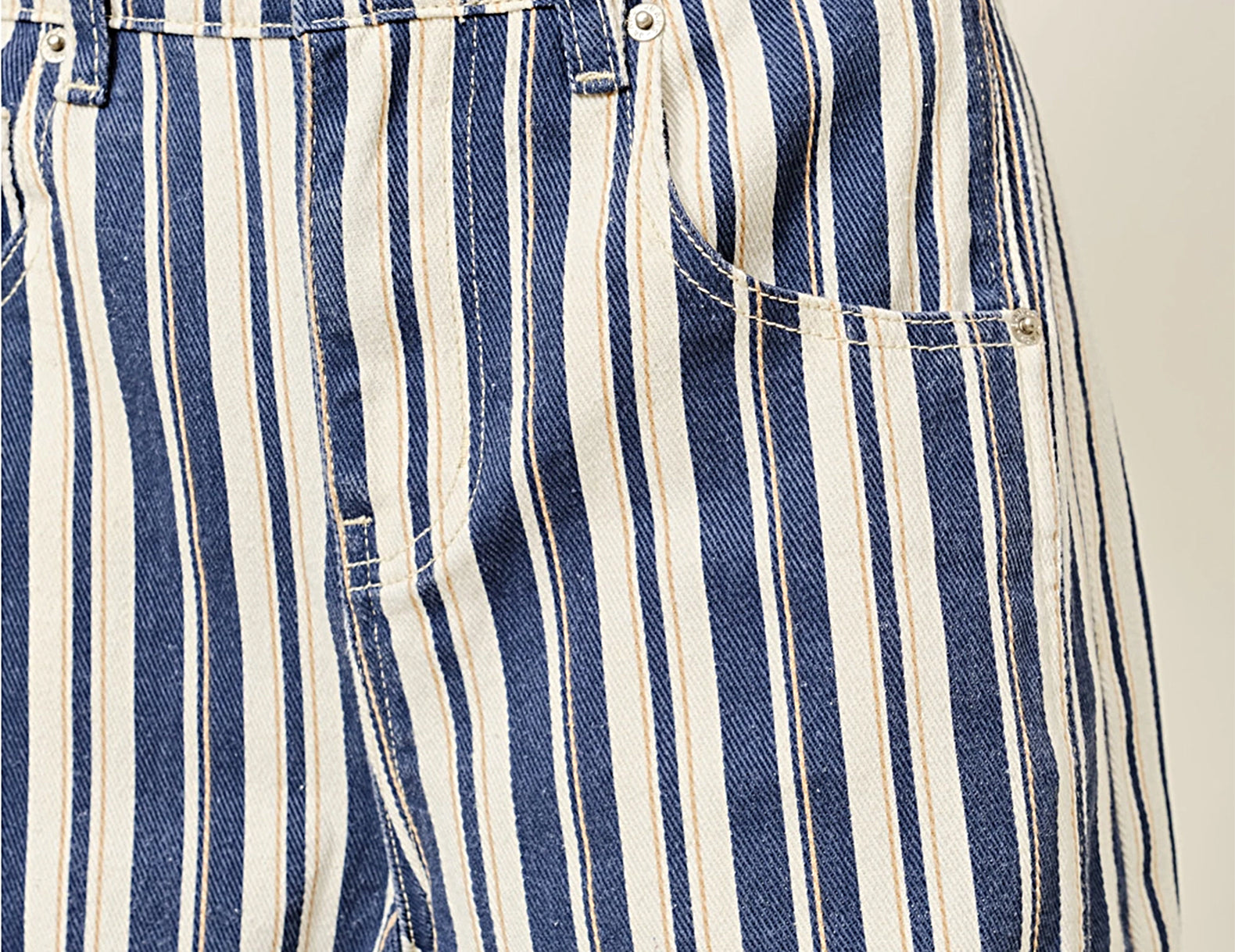 Close-up of waistband and pocket detail on striped barrel pants