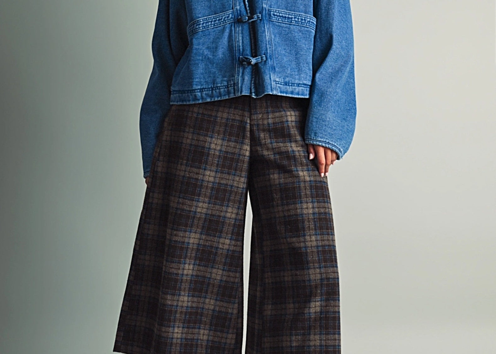 Full-length view of a model in the Faye Toggle Button Sherpa + Denim Jacket, cropped and boxy over wide-leg trousers