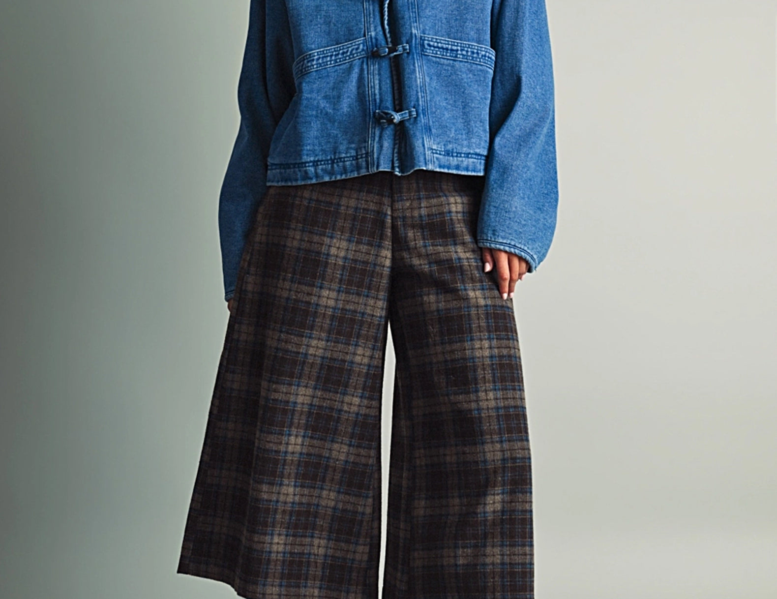 Full-length view of a model in the Faye Toggle Button Sherpa + Denim Jacket, cropped and boxy over wide-leg trousers