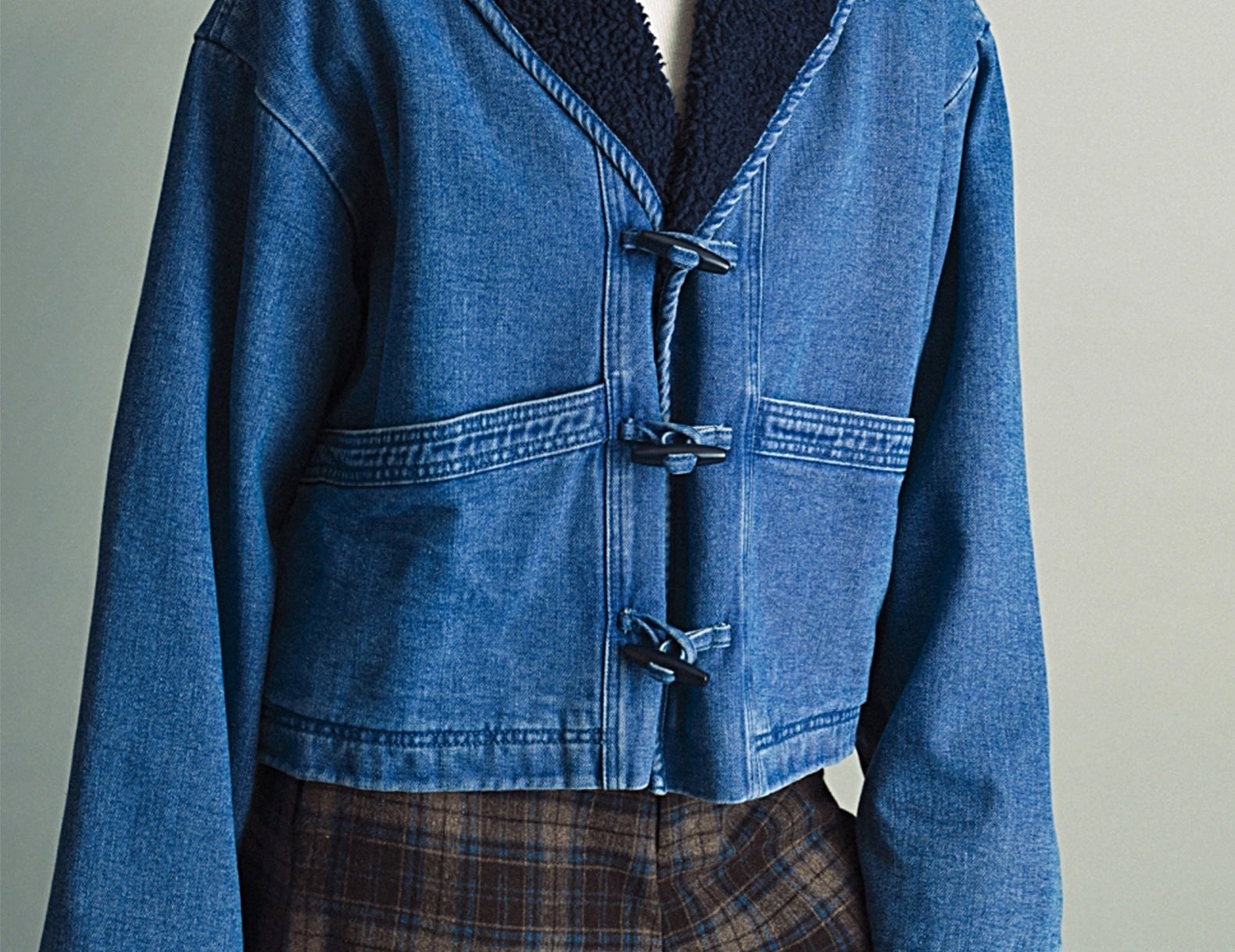 Three-quarter view of the Faye Toggle Button Sherpa + Denim Jacket showing the wide sleeves and toggle closures