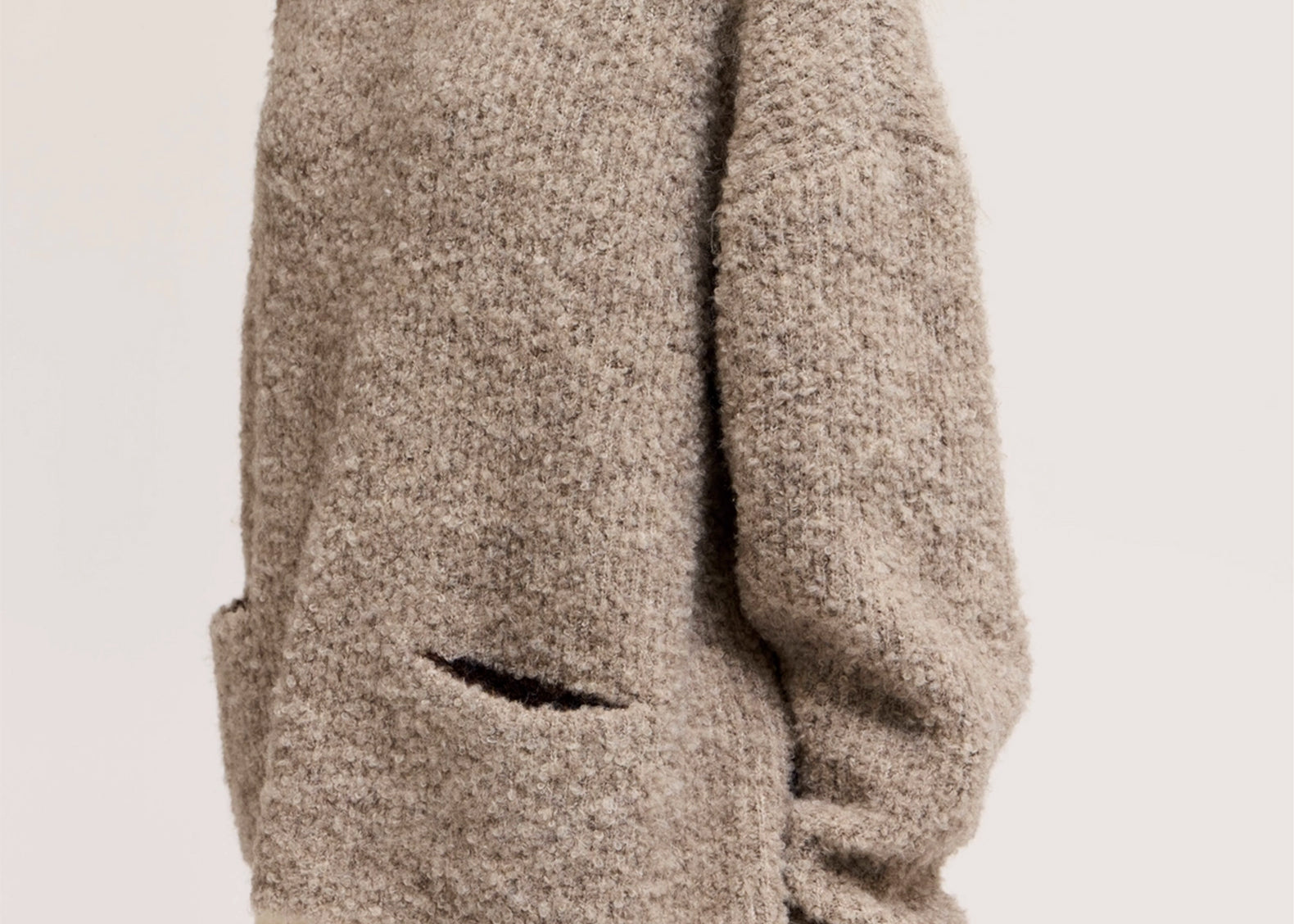 Close-up of bouclé knit texture and patch pocket on oversized sweater