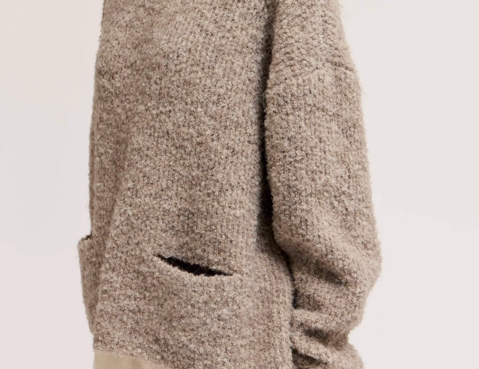 Close-up of bouclé knit texture and patch pocket on oversized sweater