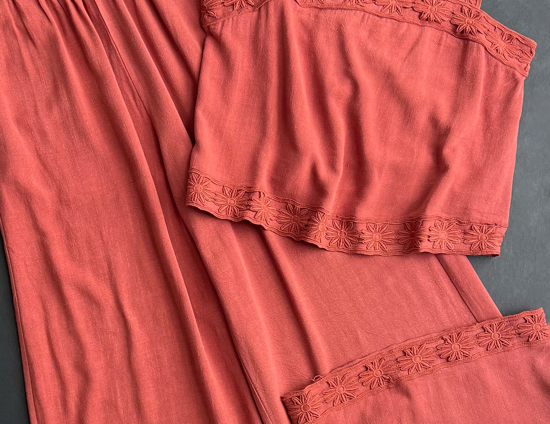Flat view of the Layla Embroidered Masala Pant, high-waisted wide-leg pants in red-brown linen-blend with daisy embroidered hems