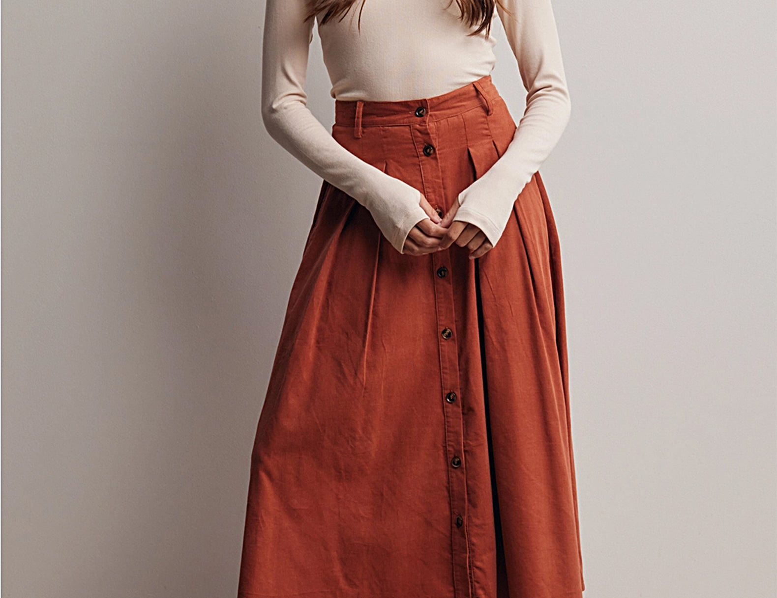 Full-length view of the Marnie Pleated Button Front Corduroy Skirt styled with a tucked-in top and suede loafers