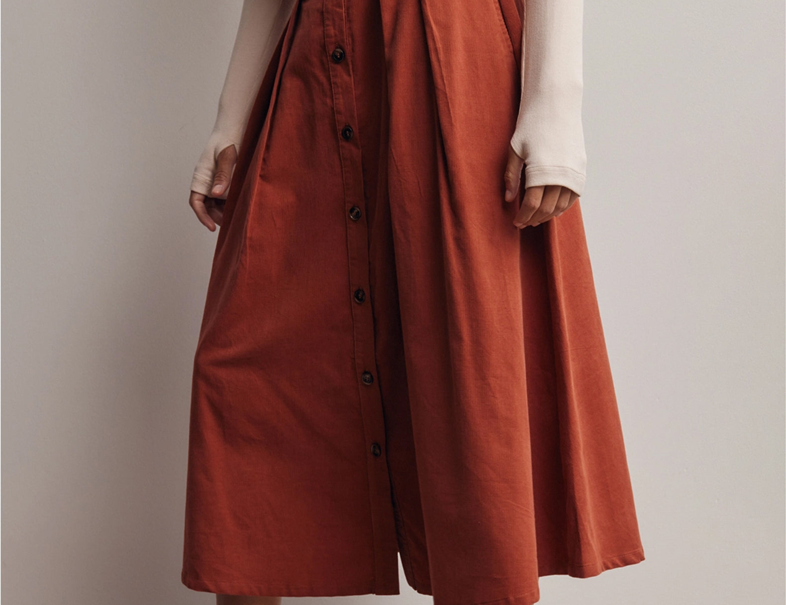 Side angle of the Marnie Pleated Button Front Corduroy Skirt showing the midi length and the button front