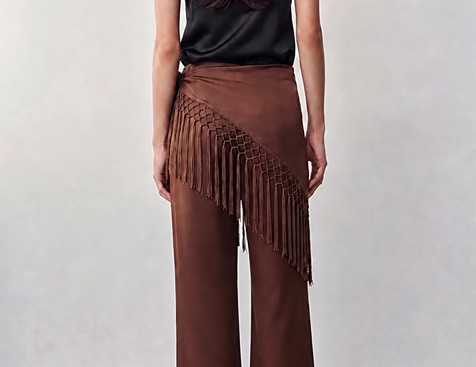 Back view of the chocolate wide-leg satin pants with the fringe scarf draped diagonally