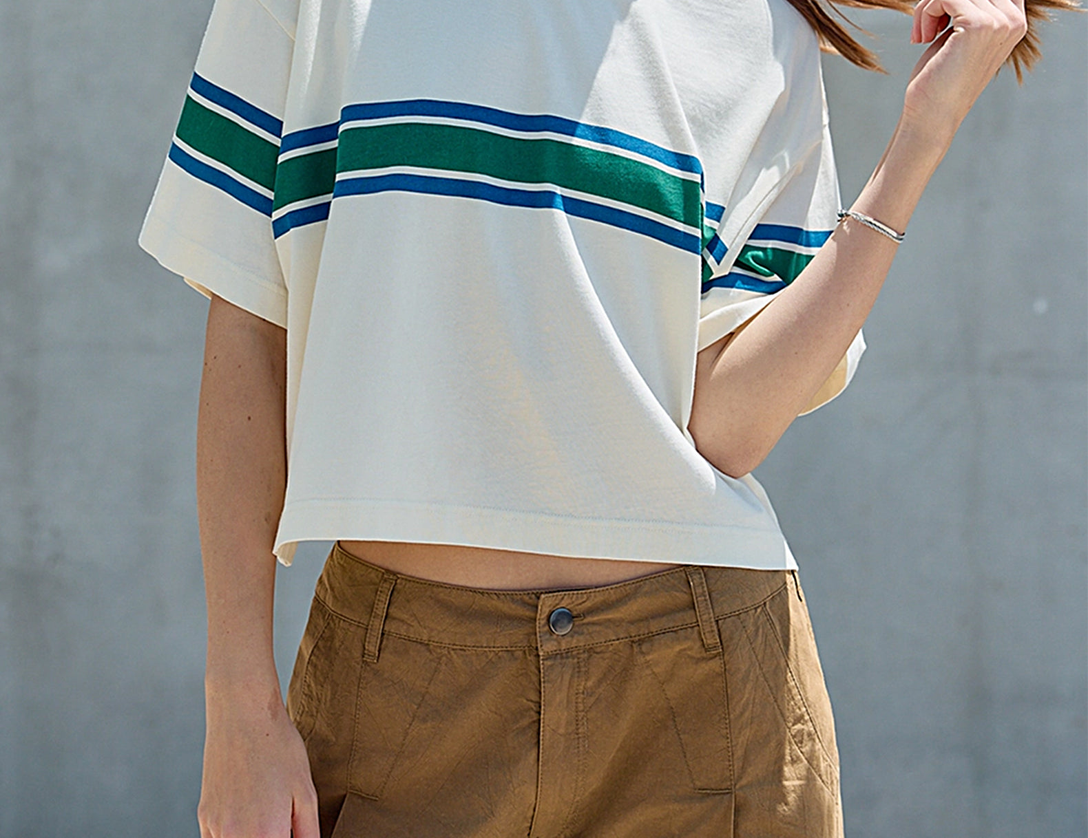 Front view of the Remi cream cropped tee with green and blue varsity stripes