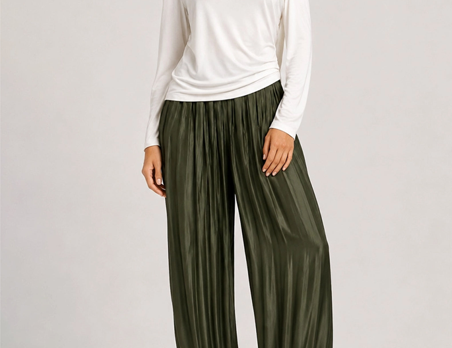 Front view of the green satin balloon pants showing their full, rounded leg