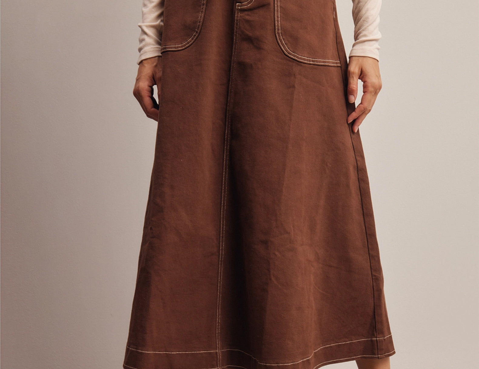 Front view of the chocolate brown Shilo A-line midi skirt styled with cream socks and brown loafers