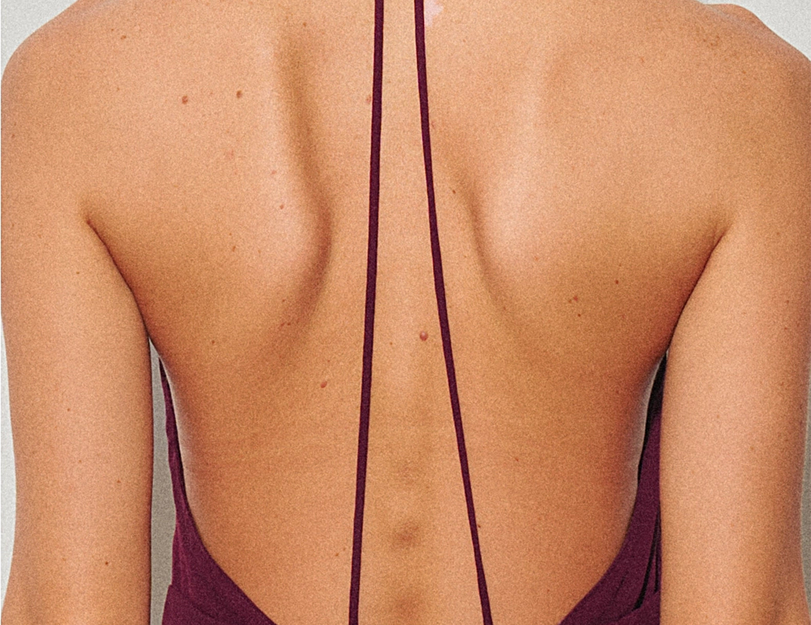 Close-up of the open back straps and triangle cutout on the halter dress